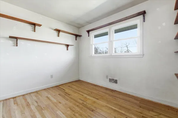 a view of walk in closet with empty racks