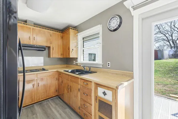 a kitchen with a stove a sink a refrigerator and a window