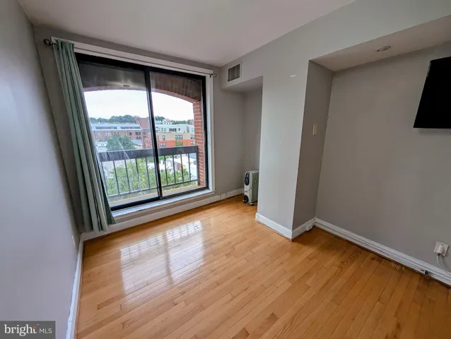 a view of a livingroom with wooden floor and a flat screen tv