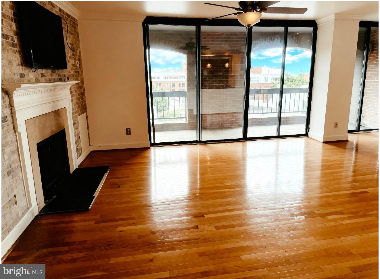 1080 Wisconsin Avenue Northwest, Unit 501 Washington, DC 20007 - Photo 6 of 36 a view of a living room with an empty space and a fireplace