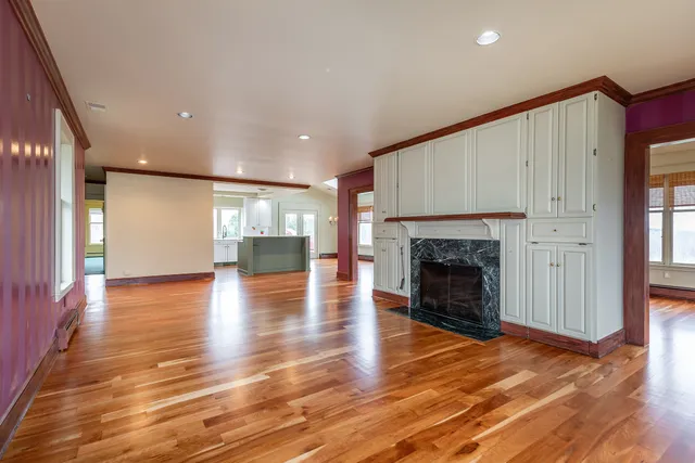 a view of a livingroom with wooden floor and a fireplace