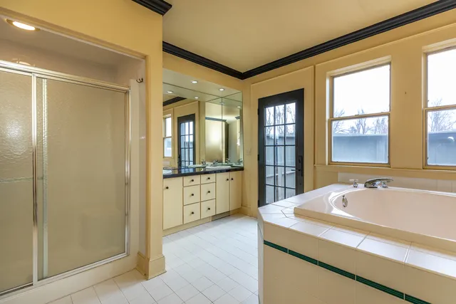 a spacious bathroom with a tub sink shower and mirror