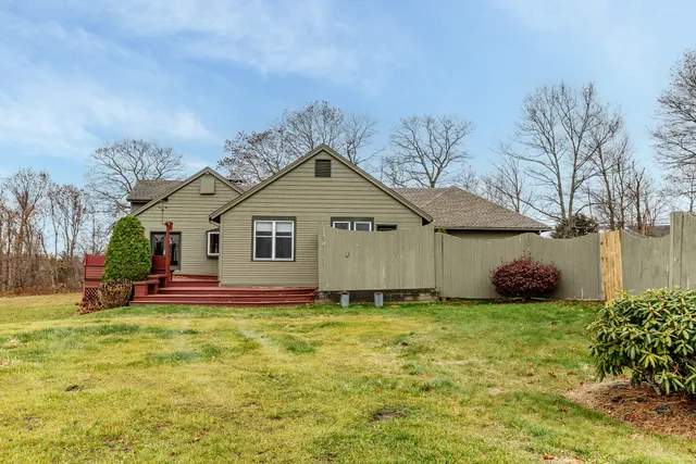 a backyard of a house with wooden floor and outdoor seating