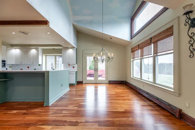 a view of an empty room with window and wooden floor