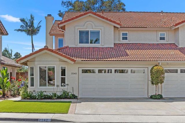a front view of a house with a yard and potted plants