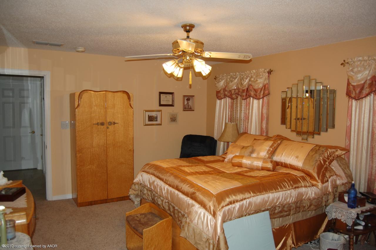 6706 Hatton Road Amarillo, TX 79110 - Photo 13 of 23 a bedroom with a bed and a chandelier