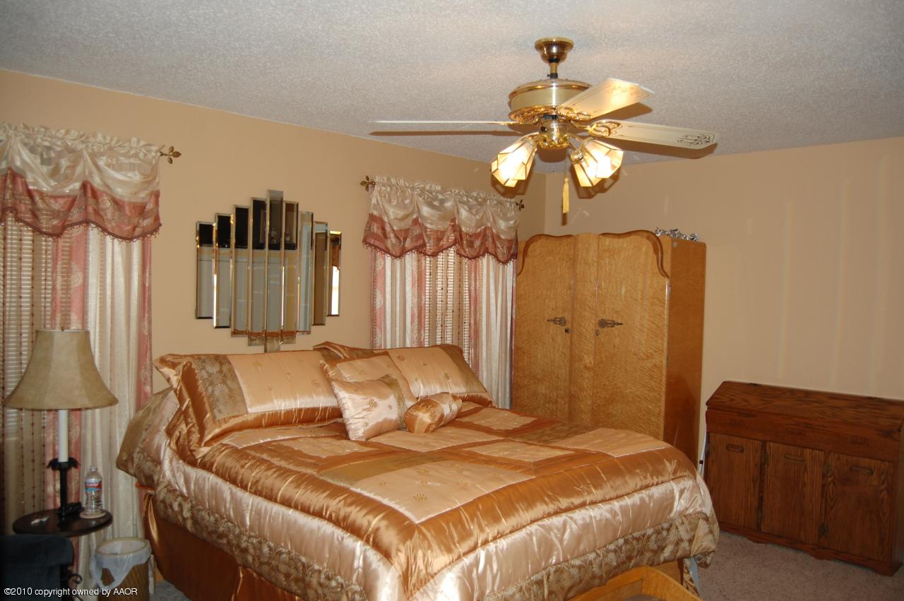 6706 Hatton Road Amarillo, TX 79110 - Photo 14 of 23 a bedroom with a bed and a chandelier