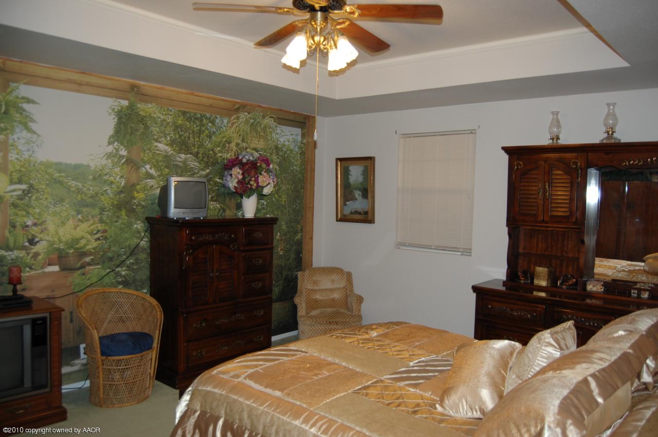 6706 Hatton Road Amarillo, TX 79110 - Photo 16 of 23 a bedroom with a bed and a chandelier