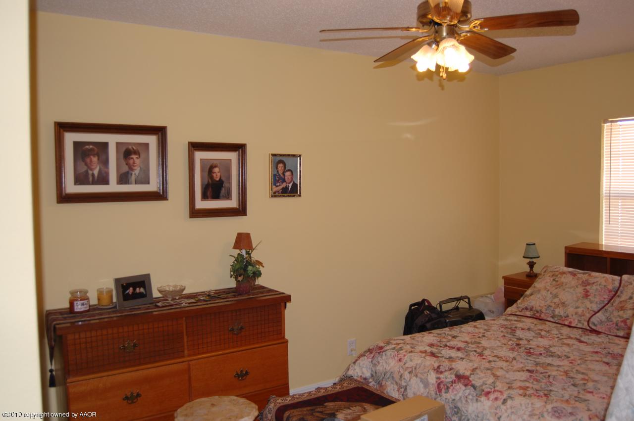 6706 Hatton Road Amarillo, TX 79110 - Photo 17 of 23 a bedroom with a bed and a chandelier