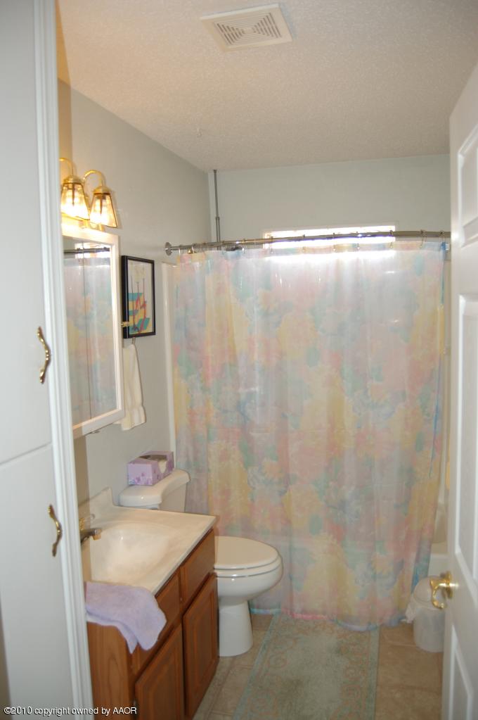 6706 Hatton Road Amarillo, TX 79110 - Photo 22 of 23 a bathroom with a sink and mirror with toilet