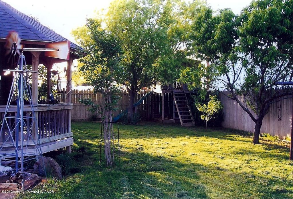 6706 Hatton Road Amarillo, TX 79110 - Photo 4 of 23 a view of a backyard with table and chairs a barbeque and a large trees with a swing