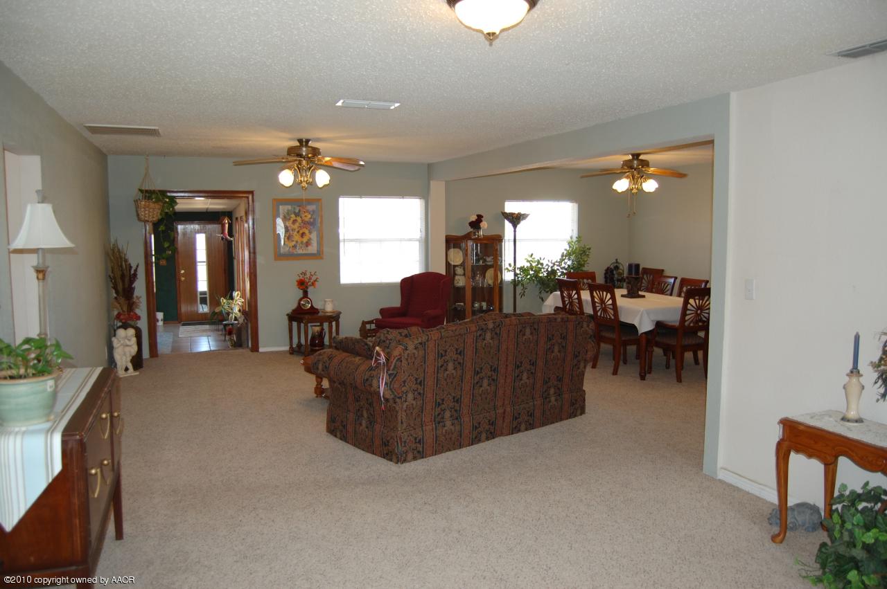 6706 Hatton Road Amarillo, TX 79110 - Photo 6 of 23 a living room with furniture and a chandelier