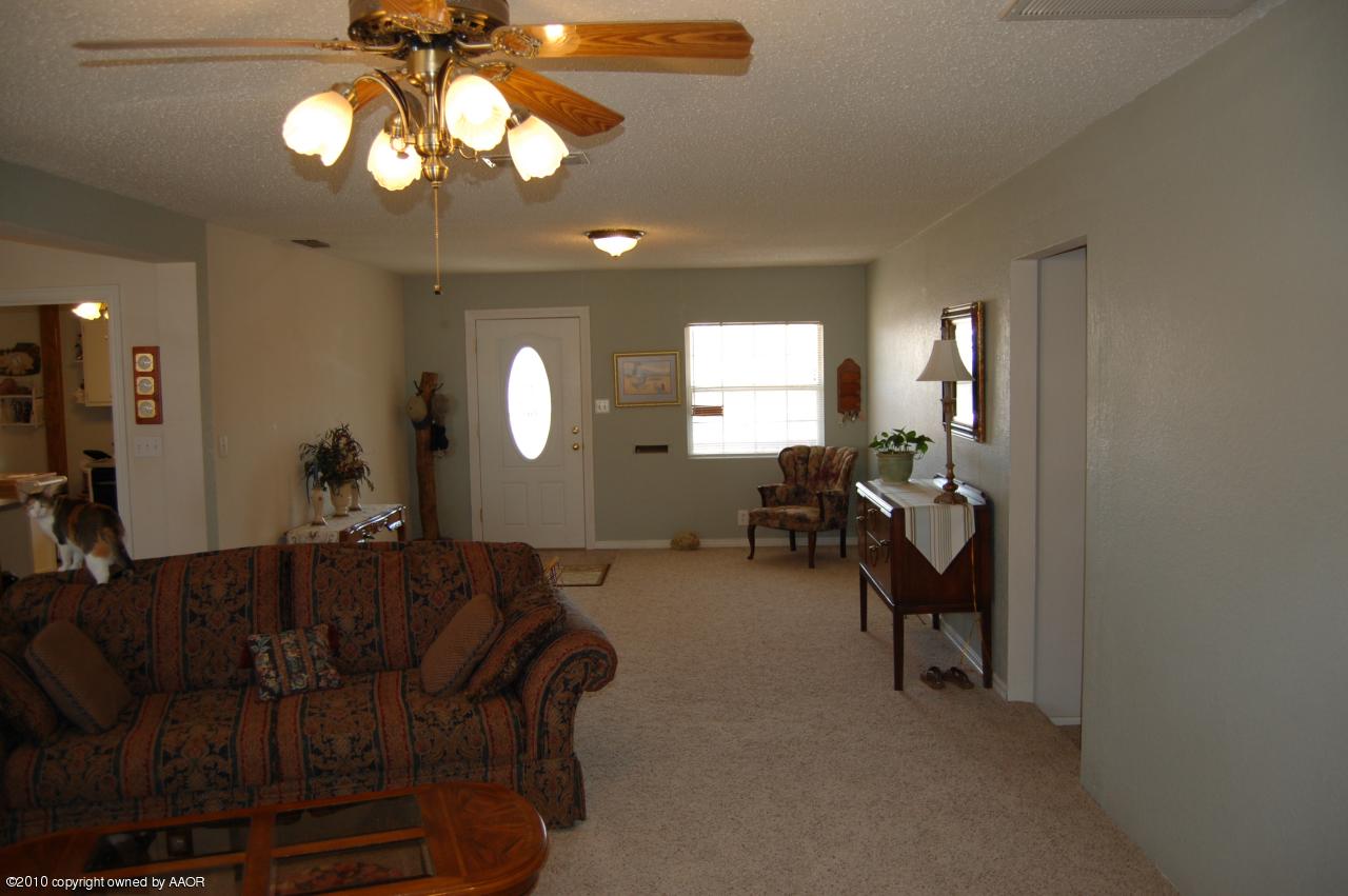 6706 Hatton Road Amarillo, TX 79110 - Photo 7 of 23 a living room with furniture a chandelier and a large mirror