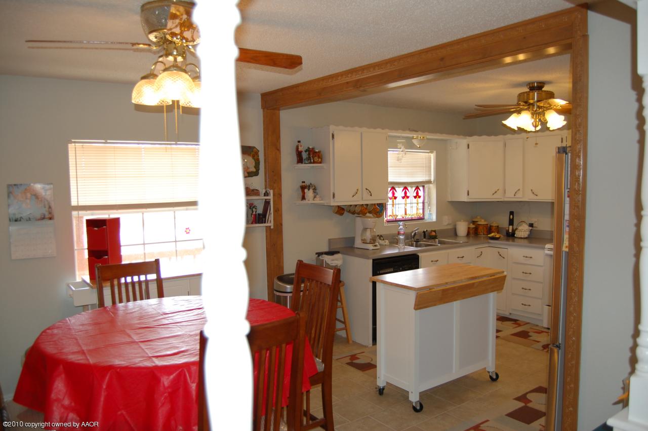 6706 Hatton Road Amarillo, TX 79110 - Photo 9 of 23 a kitchen with stainless steel appliances granite countertop a sink a stove and a wooden floors