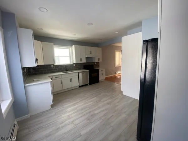 a kitchen with granite countertop a refrigerator stove and sink