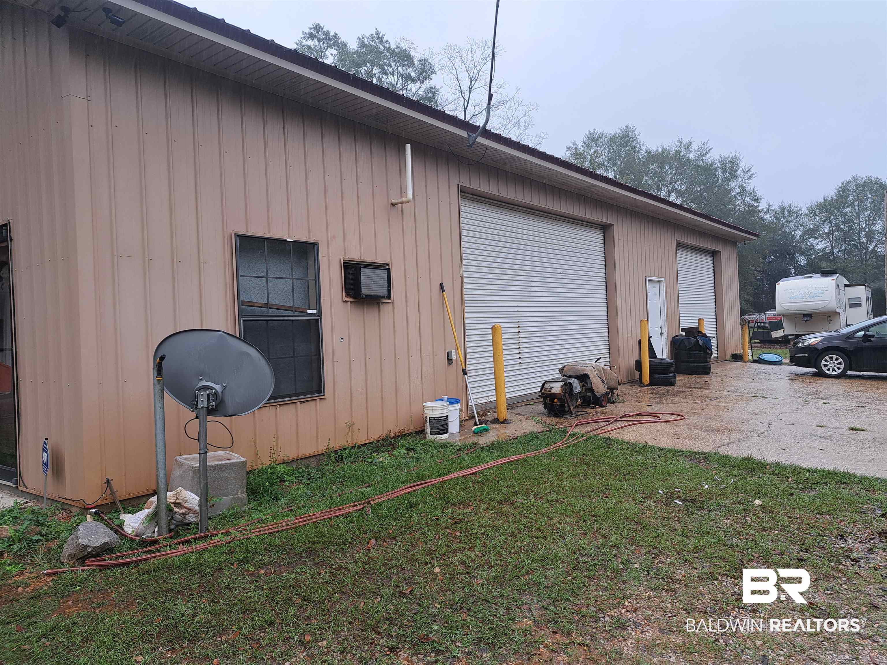 11326 Highway 31 Evergreen, AL 36401 - Photo 5 of 7 View of side of property featuring a patio area, a yard, and a garage