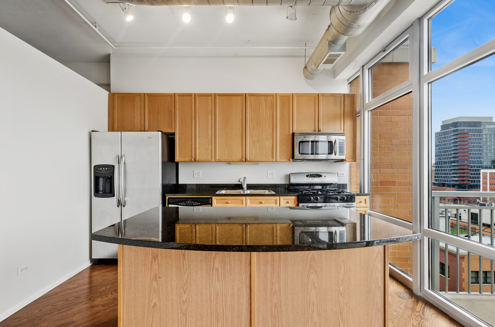 950 West Monroe Street, Unit 809 Chicago, IL 60607 - Photo 6 of 21 a kitchen with stainless steel appliances granite countertop a stove a refrigerator a sink a counter space and cabinets