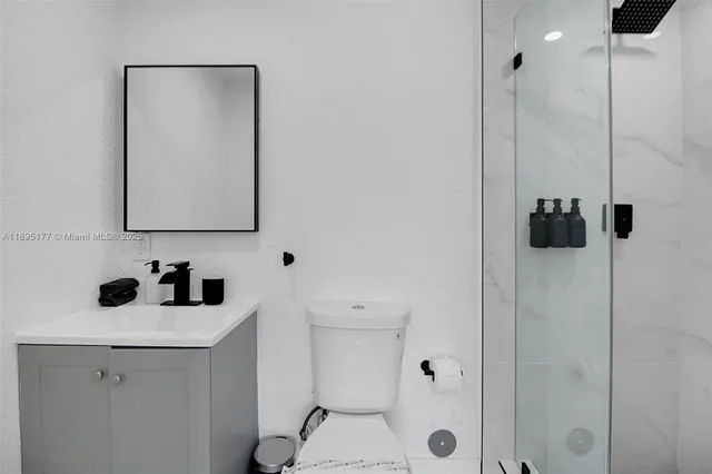a bathroom with a sink a toilet and shower