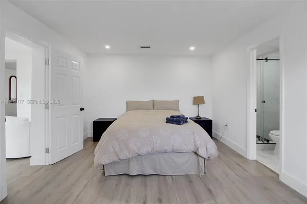 a bedroom with a bed and wooden floor