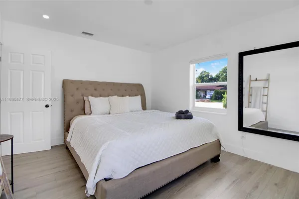 a large bed sitting in a bedroom next to a window