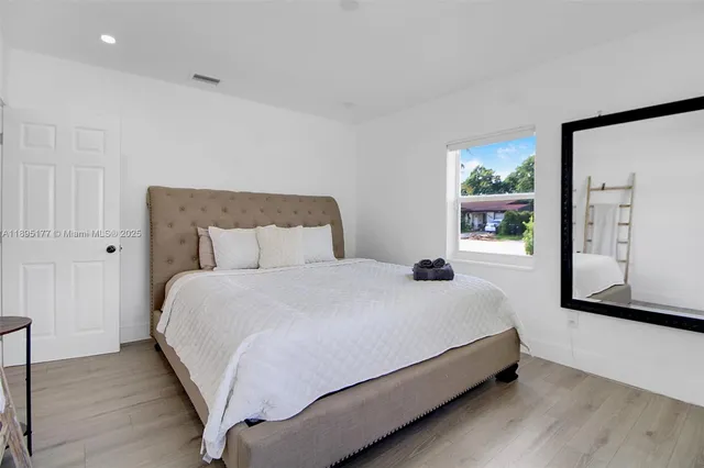 a large bed sitting in a bedroom next to a window