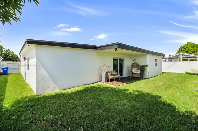 a view of a backyard with table and chairs and a barbeque