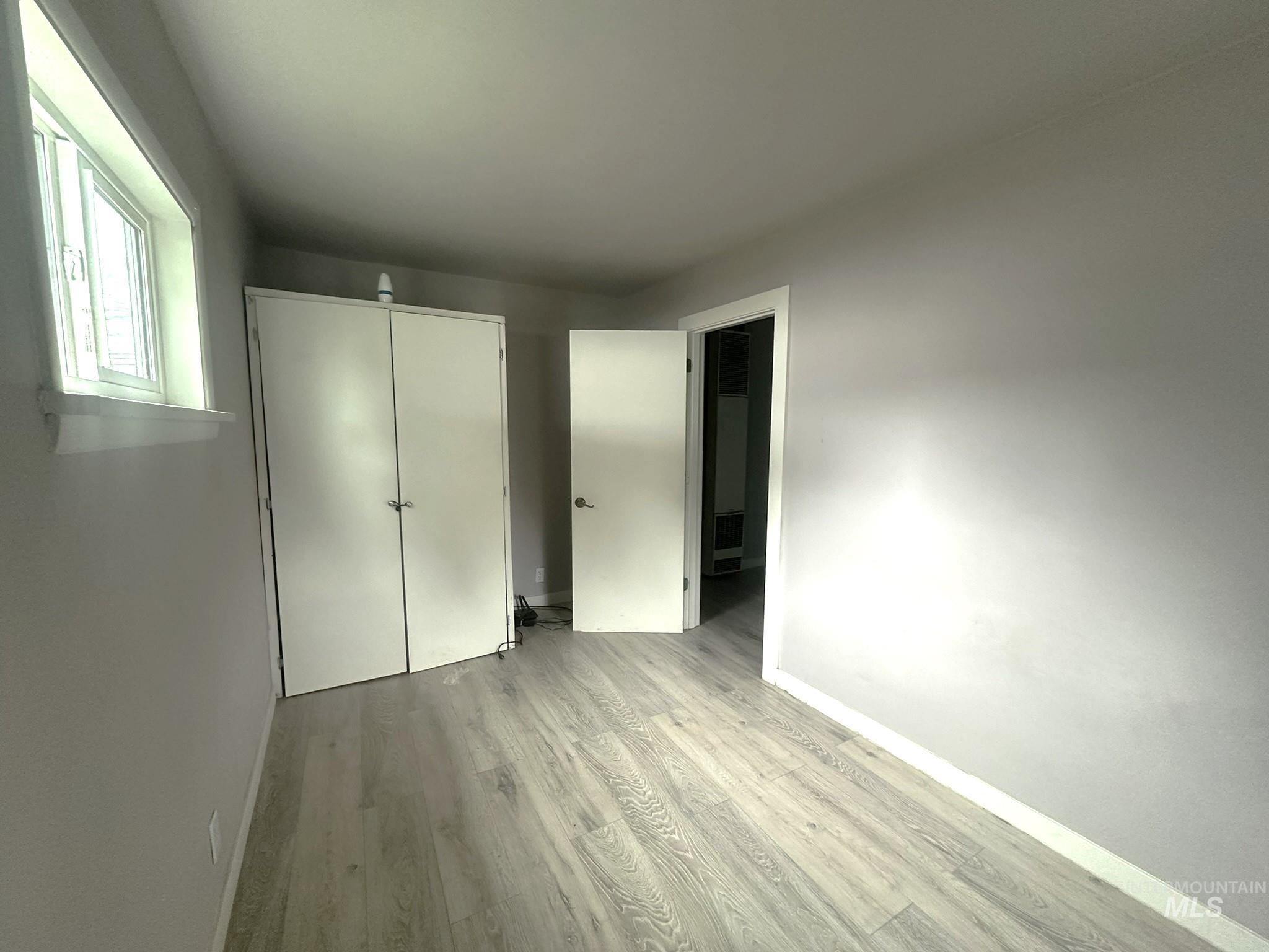 811 East Liberty Street Weiser, ID 83672 - Photo 2 of 12 Unfurnished bedroom with light wood finished floors and a closet
