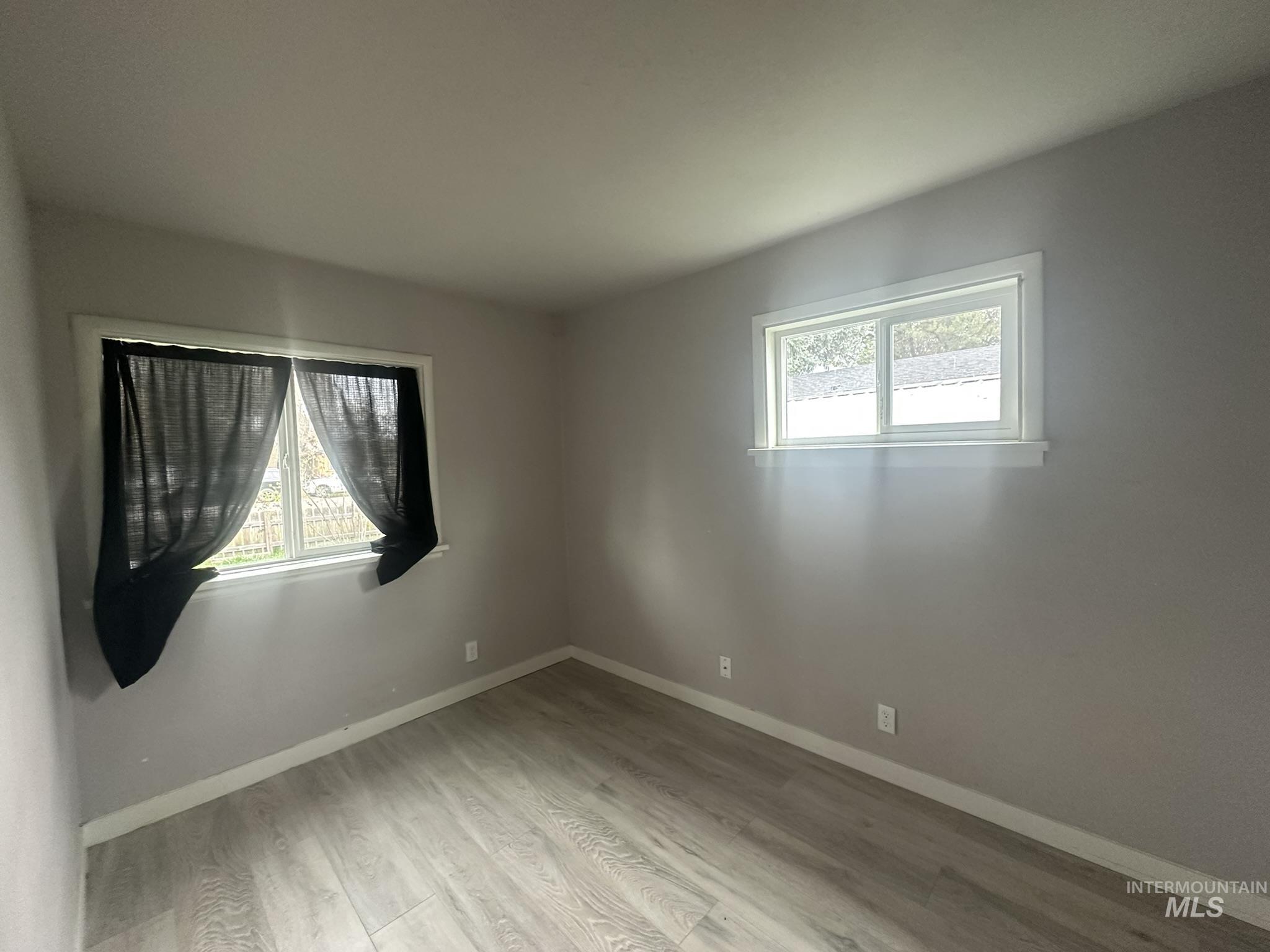 811 East Liberty Street Weiser, ID 83672 - Photo 3 of 12 Unfurnished room with light wood finished floors and healthy amount of natural light