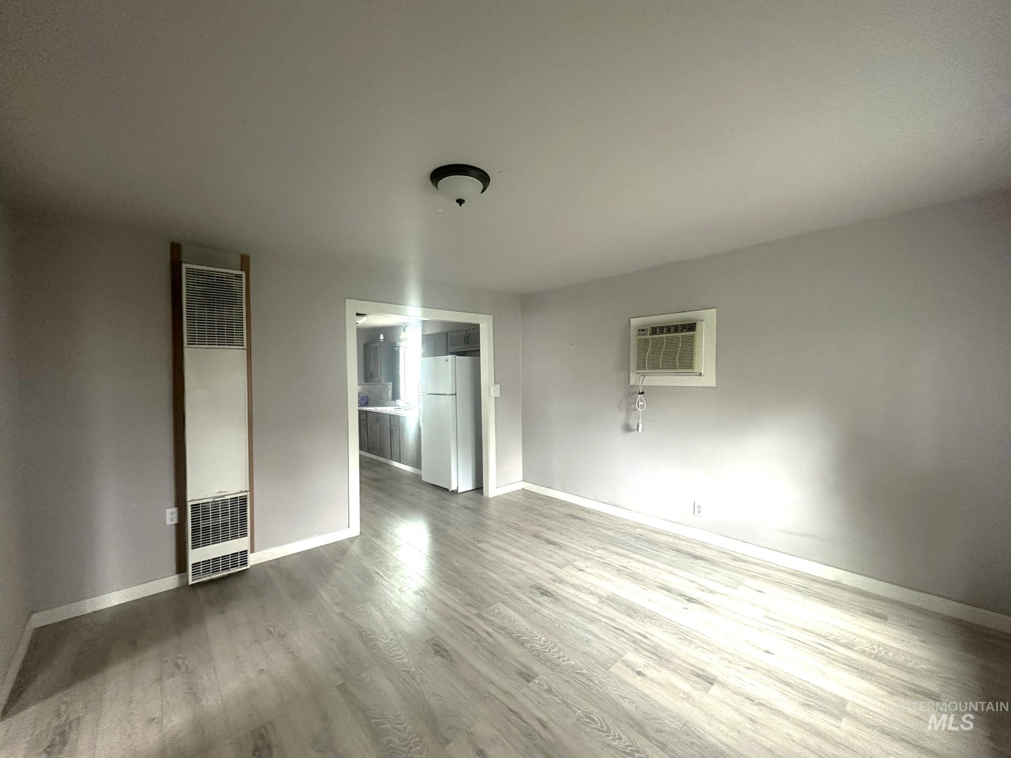 811 East Liberty Street Weiser, ID 83672 - Photo 4 of 12 Unfurnished bedroom with a heating unit, freestanding refrigerator, and light wood-style flooring
