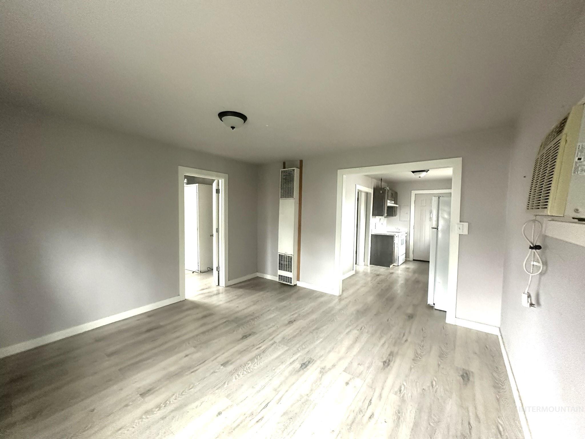 811 East Liberty Street Weiser, ID 83672 - Photo 5 of 12 Unfurnished living room featuring light wood-style flooring and a heating unit