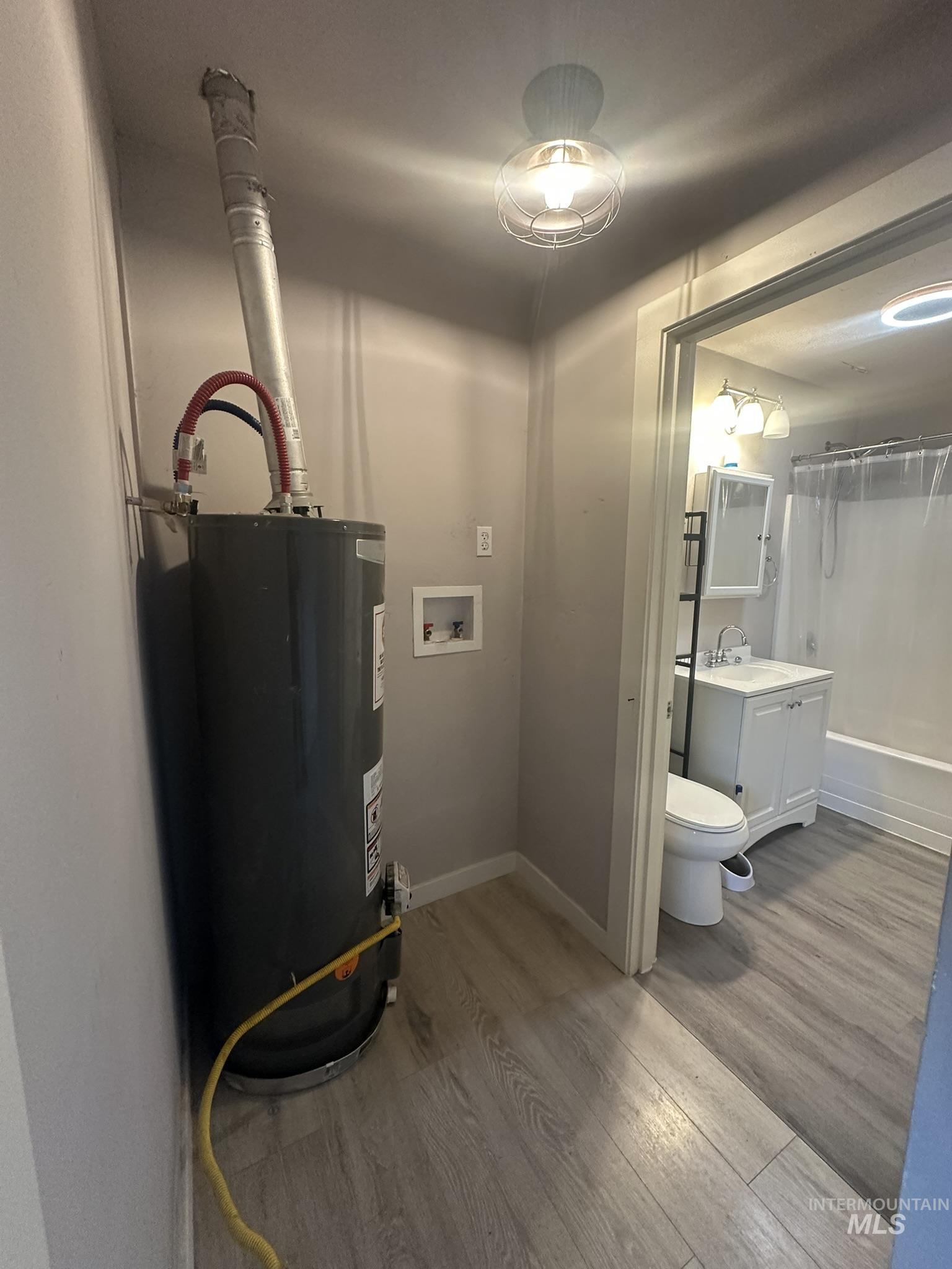 811 East Liberty Street Weiser, ID 83672 - Photo 7 of 12 Utility room featuring gas water heater and a sink
