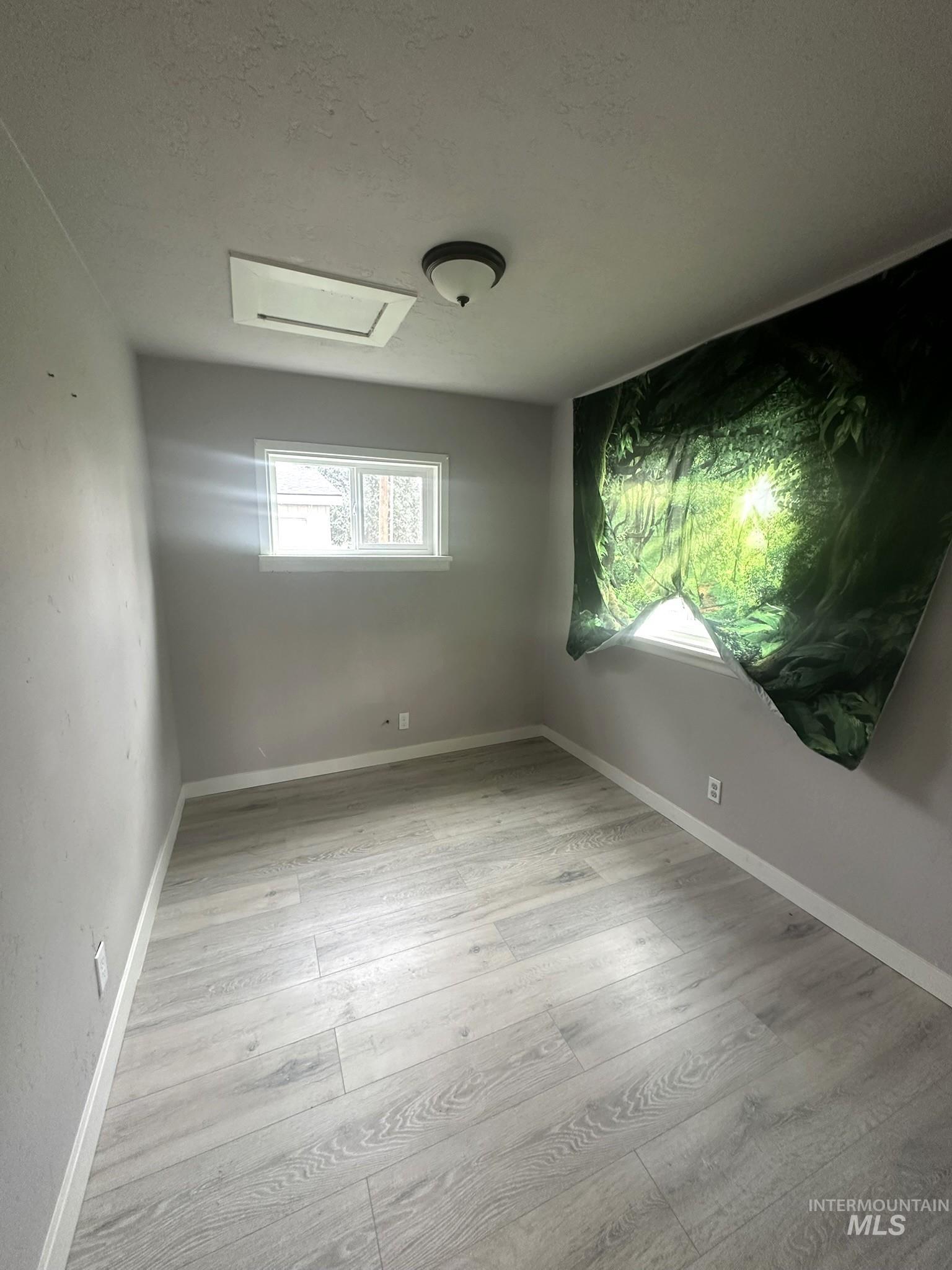811 East Liberty Street Weiser, ID 83672 - Photo 8 of 12 Unfurnished room featuring a textured ceiling and light wood-type flooring