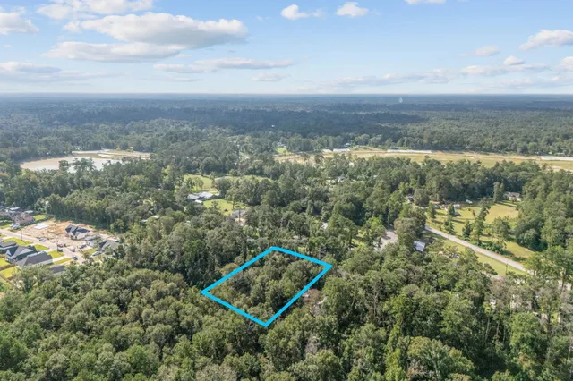 an aerial view of a house with a yard and lake view
