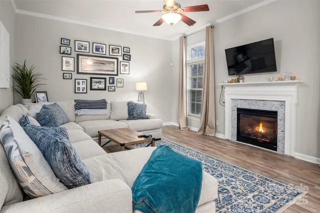 a living room with furniture a flat screen tv and a fireplace