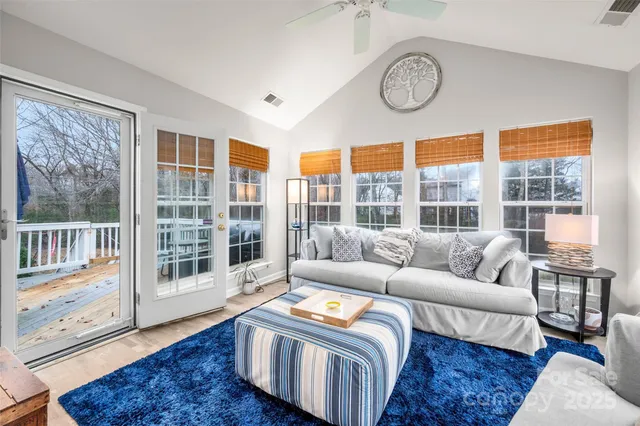 a living room with furniture a large window and wooden floor