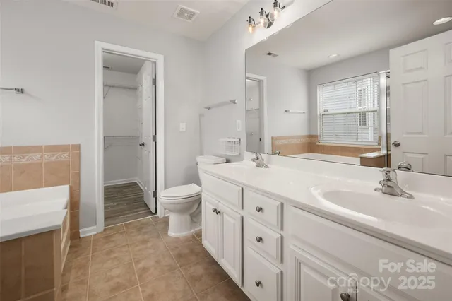 a bathroom with a double vanity sink toilet and shower