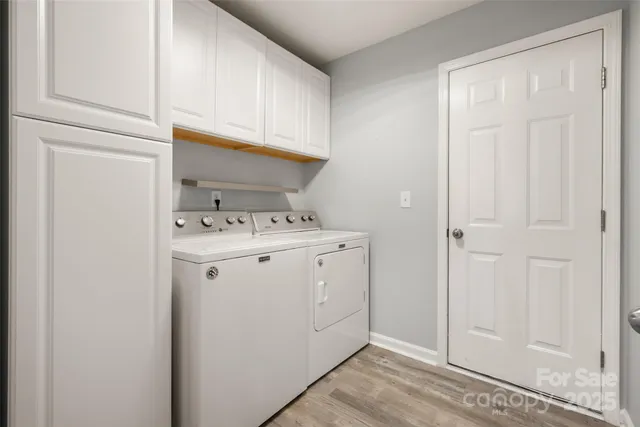 a utility room with cabinets washer and dryer