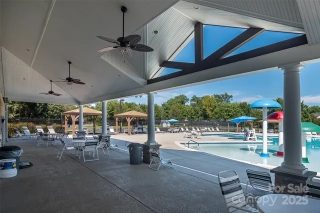 a view of a swimming pool with a table and chairs under an umbrella