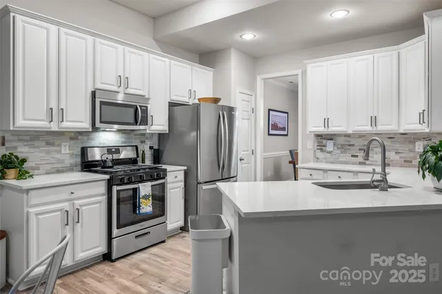 a kitchen with stainless steel appliances a stove a sink a refrigerator and cabinets