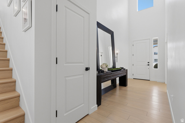 3364 Mapleton Hts Drive, Unit 101 Mapleton, UT 84664 - Photo 4 of 37 Bright foyer featuring a double-height ceiling, light wood-finish flooring, a contemporary front door with sidelight, and a light wood staircase