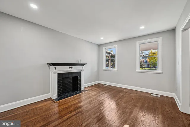 an empty room with windows and fireplace