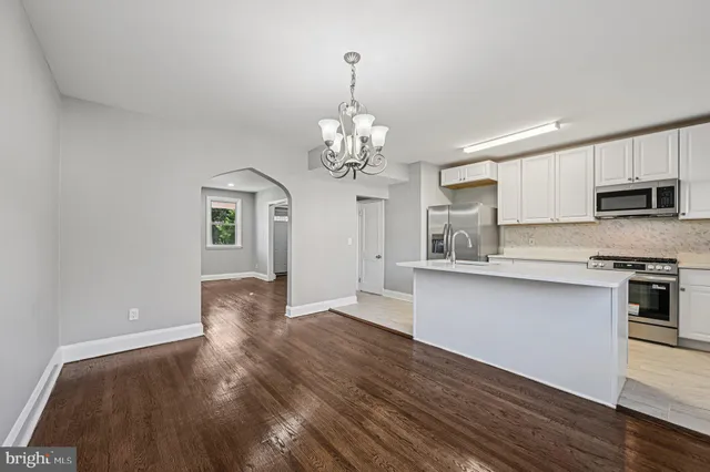 a view of a kitchen with granite countertop stainless steel appliances and wooden floor