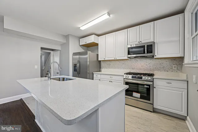 a kitchen with stainless steel appliances a stove microwave sink and refrigerator
