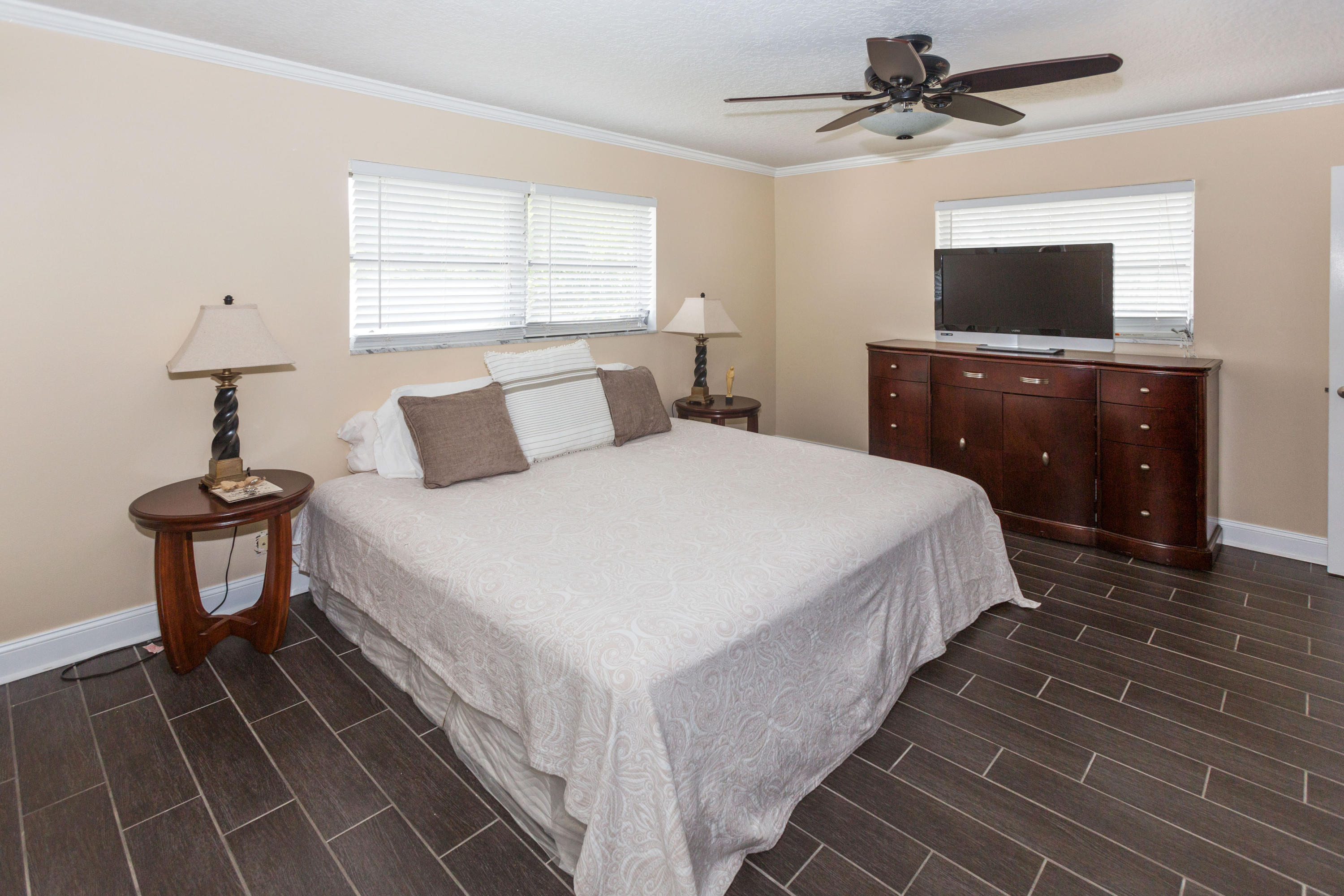 12705 Ellison Wilson Road North Palm Beach, FL 33408 - Photo 8 of 19 a bedroom with a bed and a flat tv screen on dresser