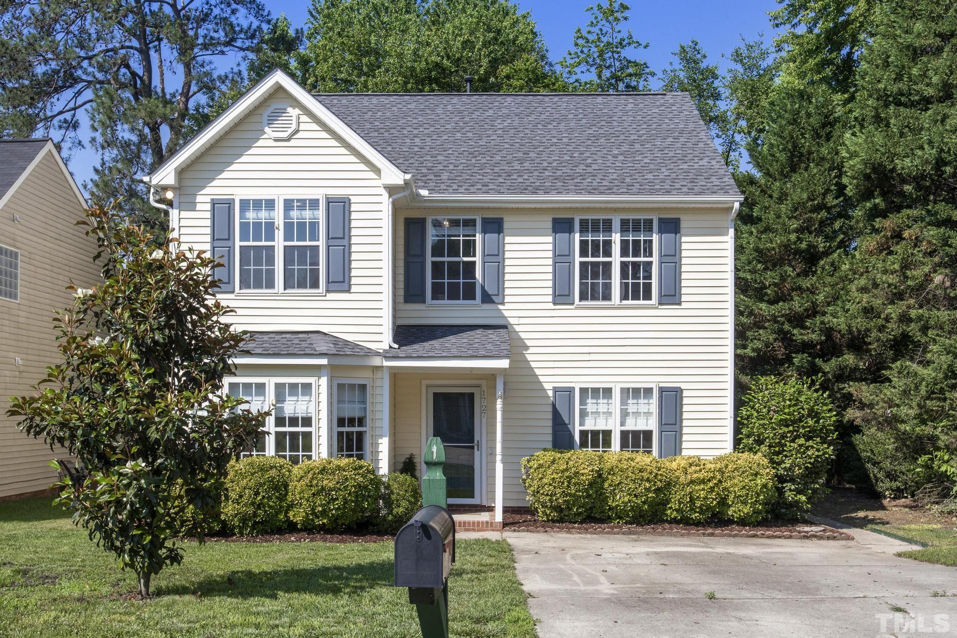 a front view of a house with a yard and plants