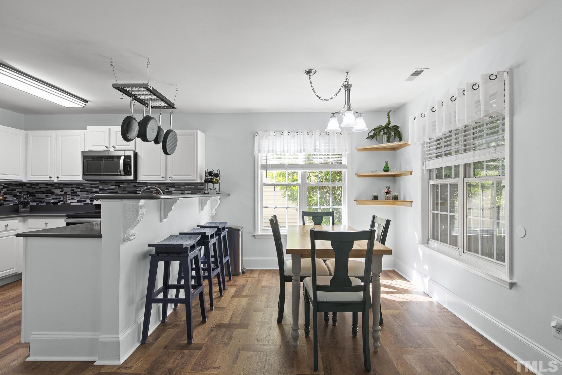 1727 Crag Burn Lane Raleigh, NC 27604 - Photo 12 of 43 a kitchen with stainless steel appliances a dining table chairs sink and cabinets