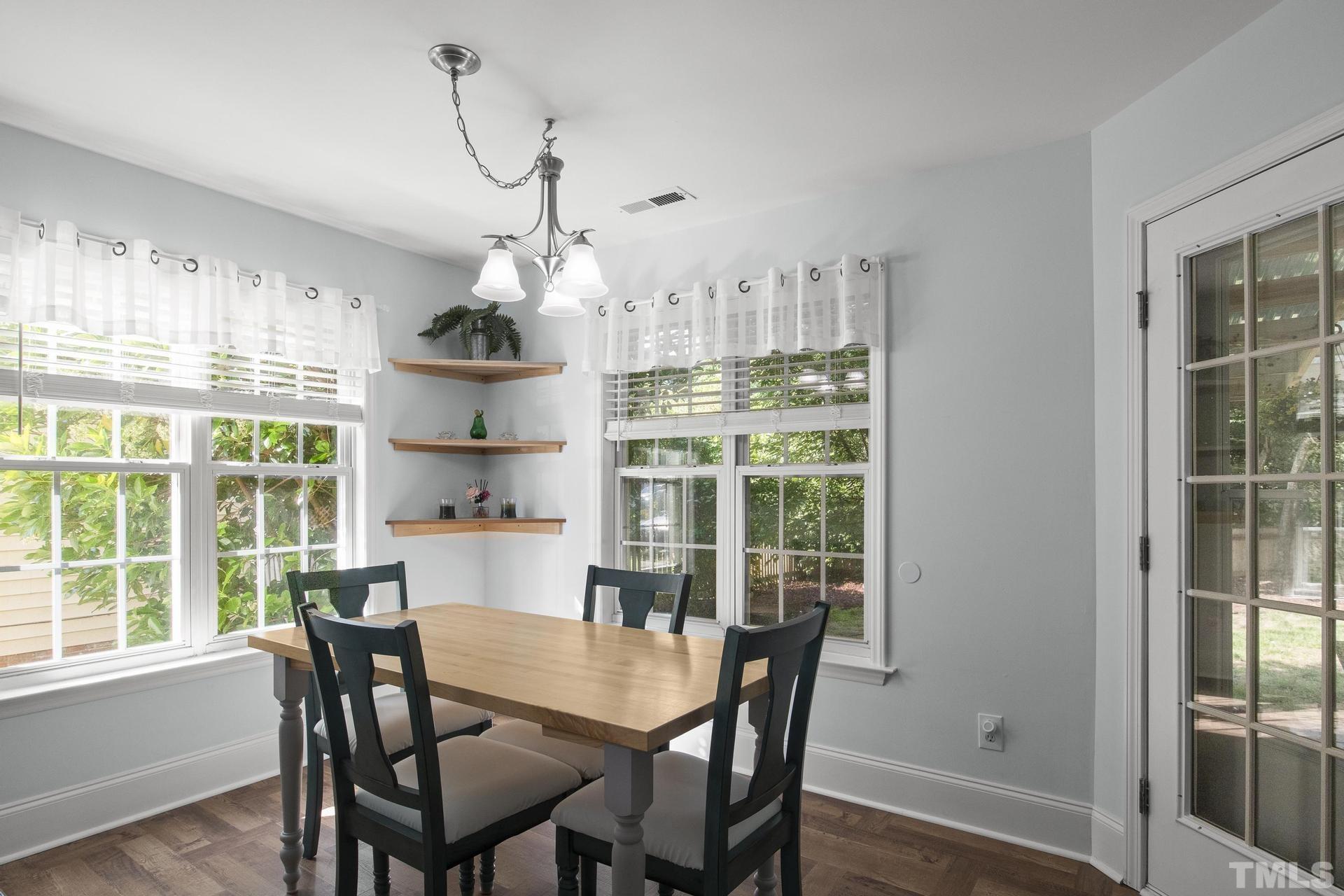1727 Crag Burn Lane Raleigh, NC 27604 - Photo 13 of 43 a dining room with wooden floor a chandelier a wooden table and chairs
