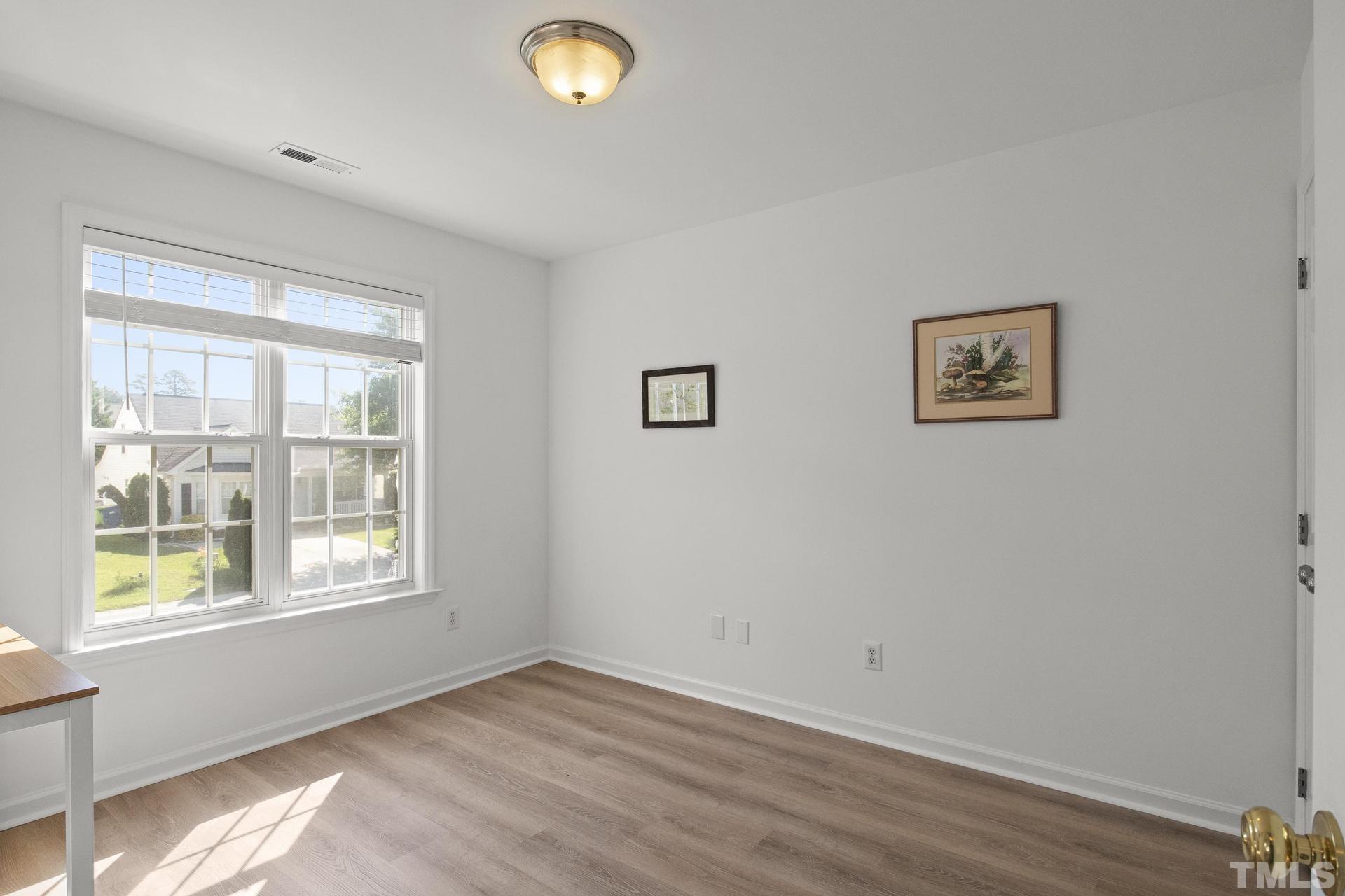 1727 Crag Burn Lane Raleigh, NC 27604 - Photo 22 of 43 a view of an empty room with wooden floor and a window