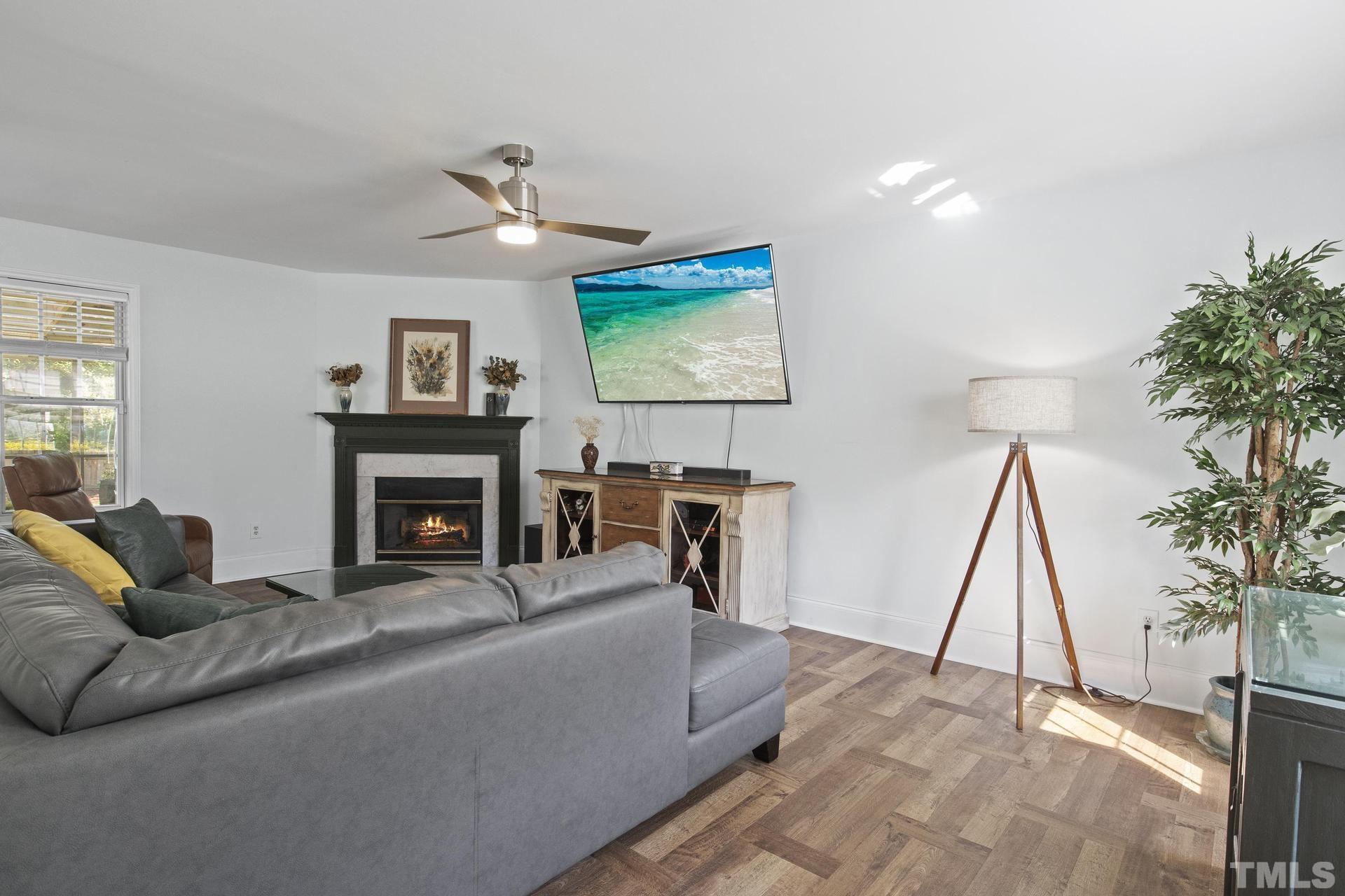 1727 Crag Burn Lane Raleigh, NC 27604 - Photo 3 of 43 a living room with furniture a fireplace and a flat screen tv