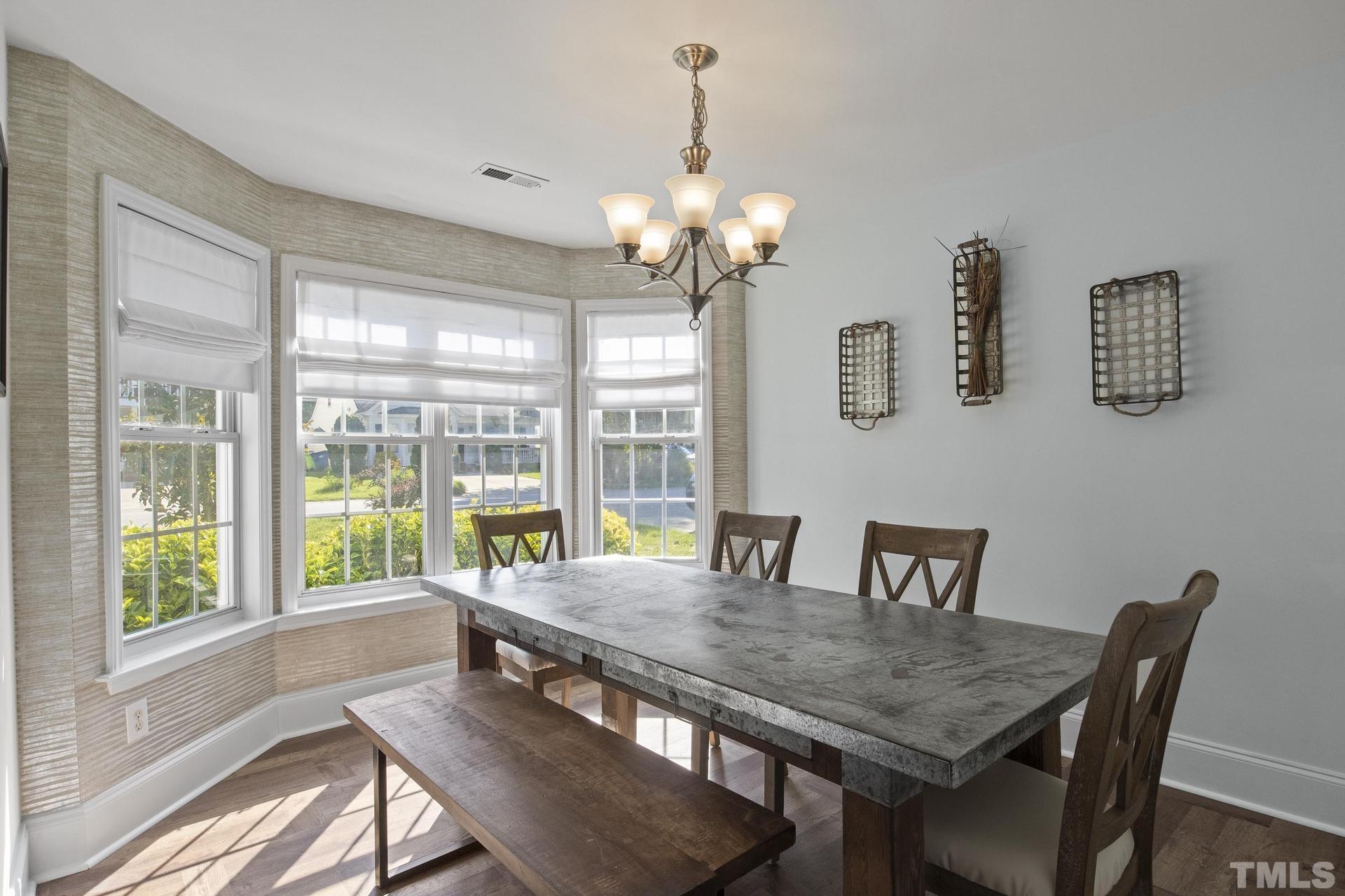 1727 Crag Burn Lane Raleigh, NC 27604 - Photo 6 of 43 a view of a dining room with furniture a chandelier and wooden floor